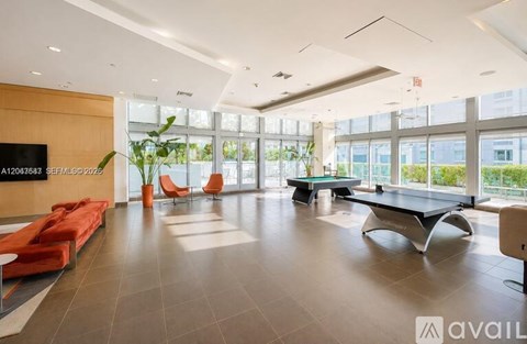 A spacious waiting area with orange chairs and a long bench.