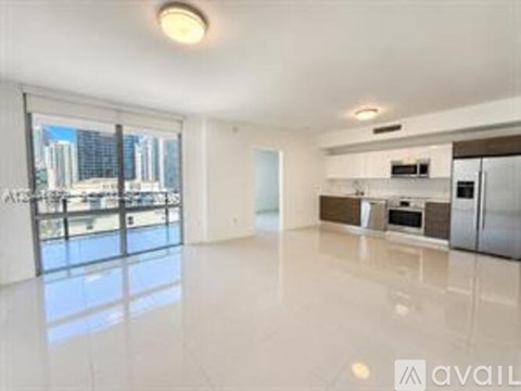 A spacious, empty living room with a view of the city skyline.