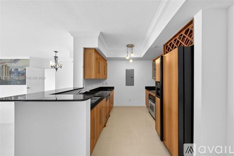 A kitchen with black countertops and wooden cabinets.