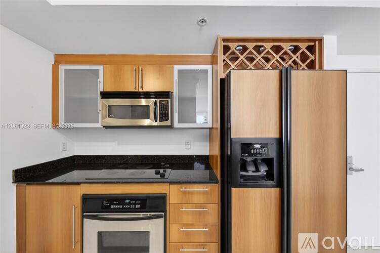 A kitchen with wooden cabinets and a black countertop.
