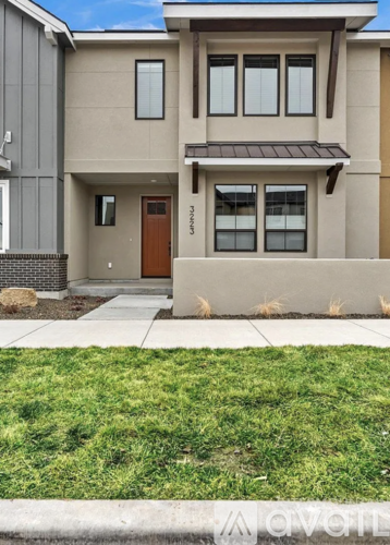 A modern house with a brown door and a small front yard.