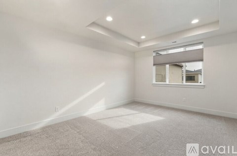 A spacious room with a window and a carpet on the floor.