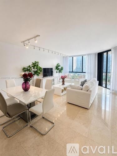A modern dining room with a white table and chairs.