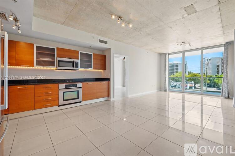 A spacious kitchen with wooden cabinets and a black countertop.