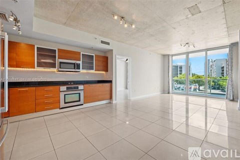 A spacious kitchen with wooden cabinets and a black countertop.
