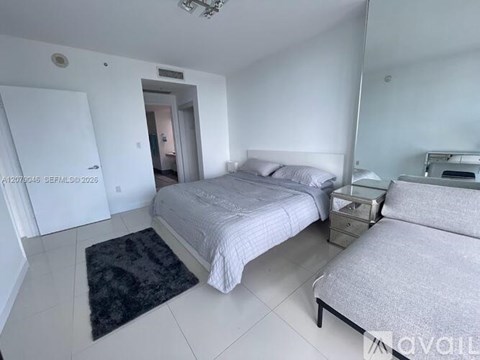 A bedroom with a large bed and a smaller bed on the side.
