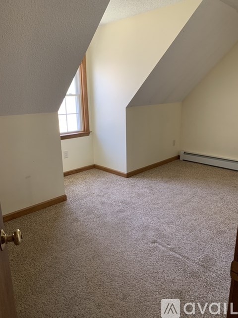 A room with a carpeted floor and a window.