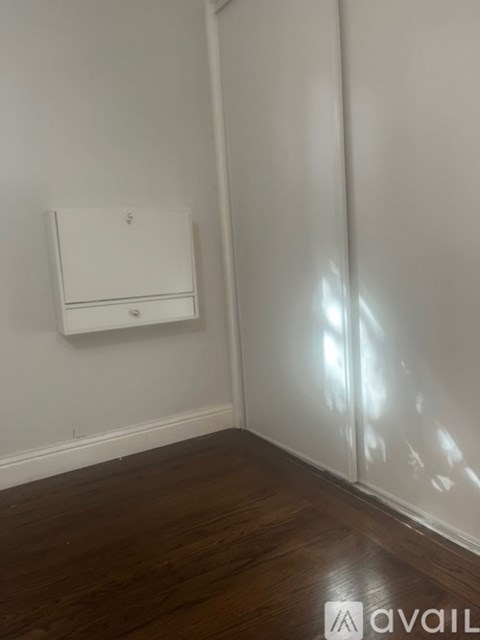 A wall-mounted light fixture in a room with wooden floors.