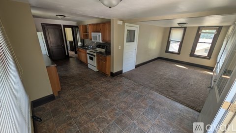A kitchen with a tile floor and a dining area with a table and chairs.