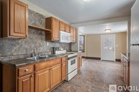 A kitchen with wooden cabinets and a tiled floor.