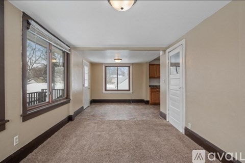 A spacious hallway with a carpeted floor and a door on the right.