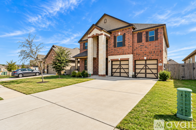 A house with a garage and a driveway in front of it.