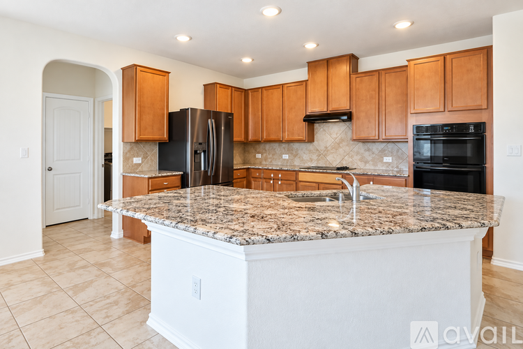 A kitchen with granite countertops and wooden cabinets.
