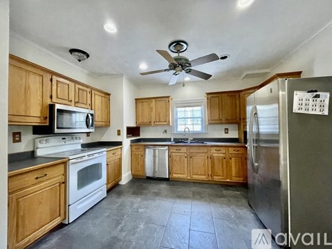 A kitchen with wooden cabinets and a stainless steel refrigerator.