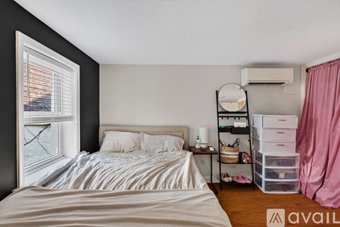 A bedroom with a large bed and a window overlooking a body of water.