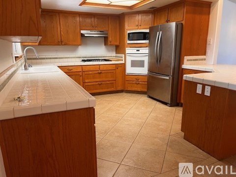 A kitchen with wooden cabinets and a refrigerator.