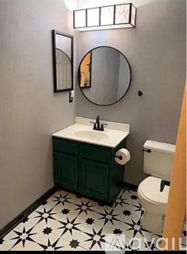 A bathroom with a green cabinet and a white sink.