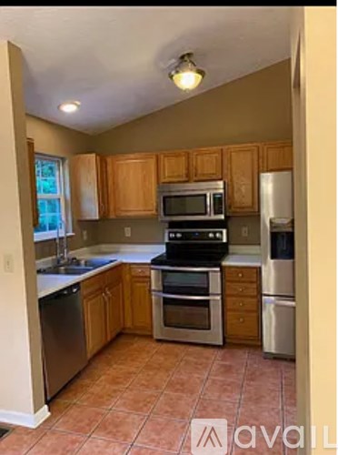 A kitchen with brown cabinets and a black stove top oven.