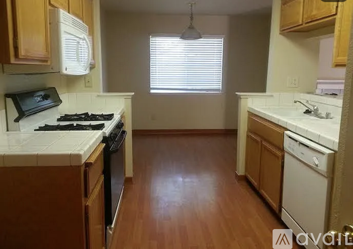 A kitchen with wooden cabinets and a black stove top.