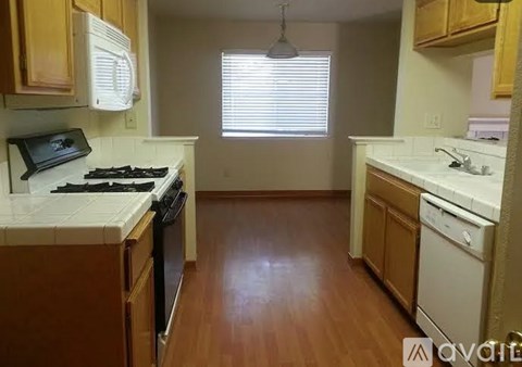 A kitchen with wooden cabinets and a black stove top.