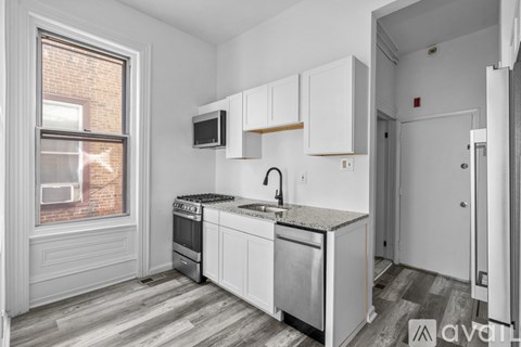 A kitchen with white cabinets and a brick window.