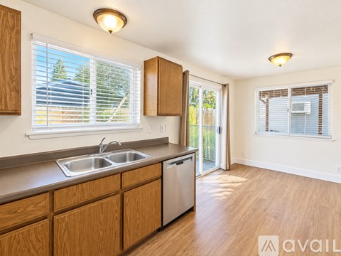 A kitchen with wooden cabinets and a stainless steel sink.
