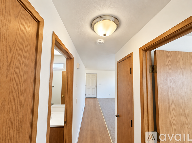 A hallway with wooden doors and a light on the ceiling.