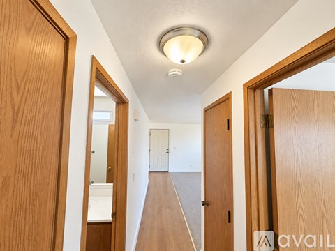 A hallway with wooden doors and a light on the ceiling.