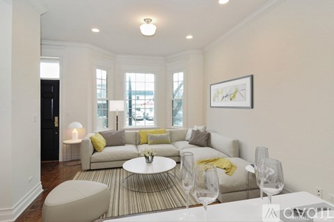 A living room with a couch, a coffee table, and a painting on the wall.