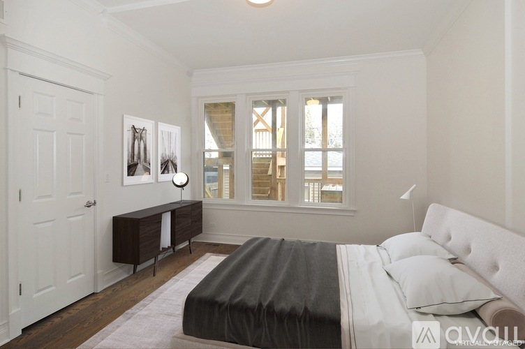 A bedroom with a large bed and a window with blinds.