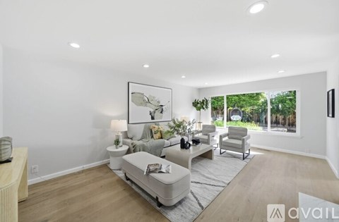 A modern living room with a large couch and a painting on the wall.