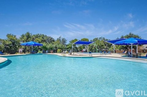 A large swimming pool surrounded by blue umbrellas.