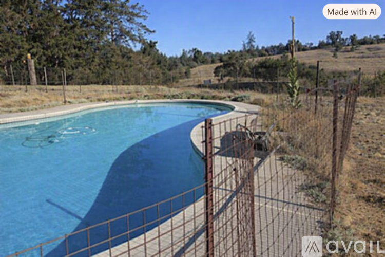 A pool surrounded by a fence with trees in the background.