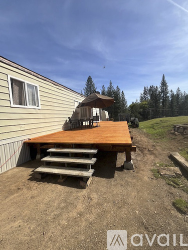A wooden deck with steps leading up to a small gazebo.