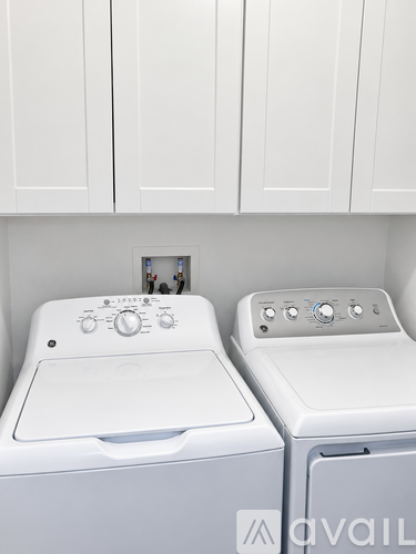 Two white front loading washing machines in a laundry room.