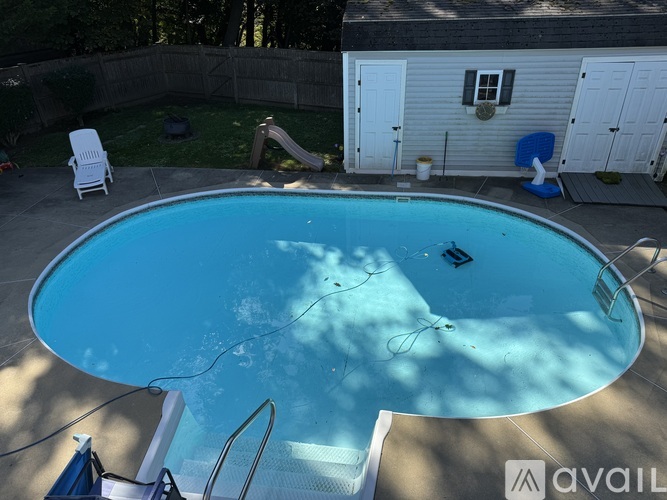 A pool with a slide and a house in the background.