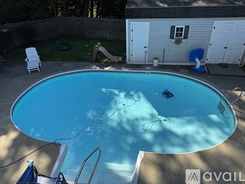 A pool with a slide and a house in the background.