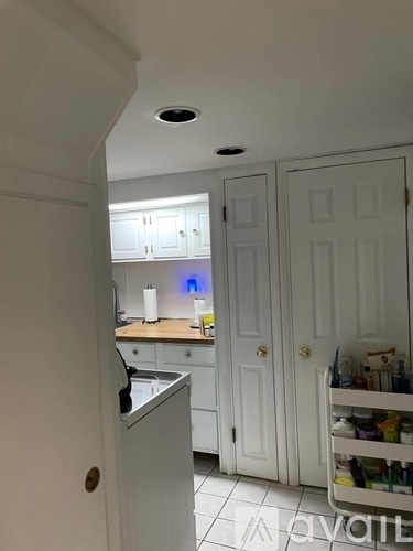 A kitchen with white cabinets and a white fridge.