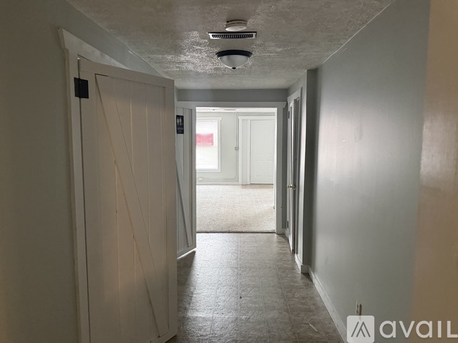 A long hallway with a door on the left and a door on the right.