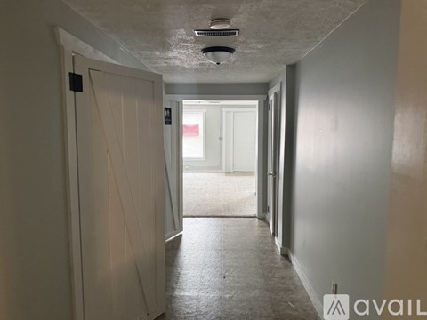 A long hallway with a door on the left and a door on the right.