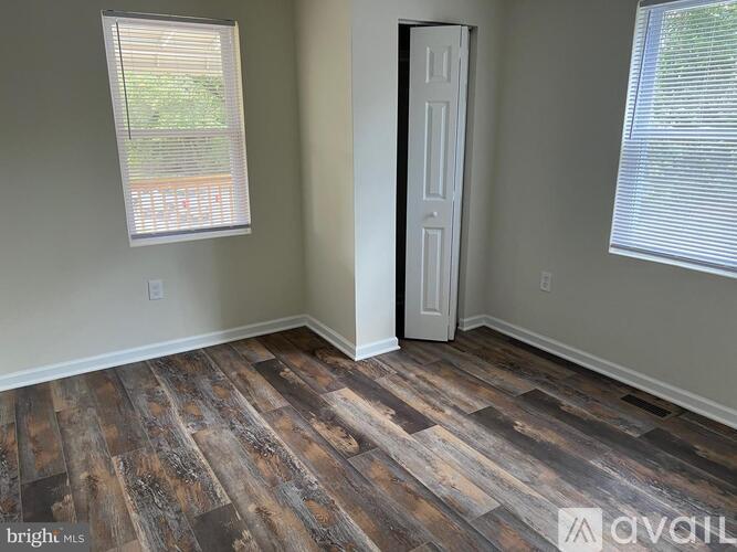 A room with wooden flooring and a white door.