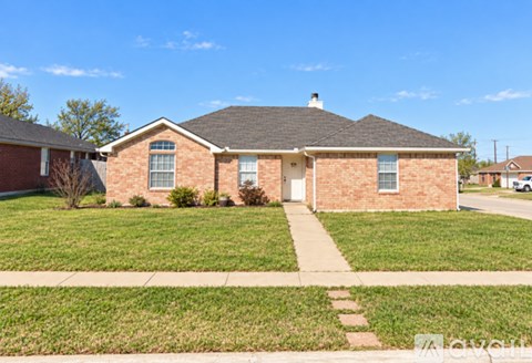 A brick house with a white door and windows.