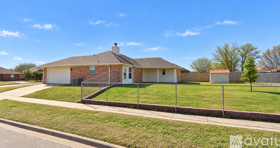 A house with a fence and a tree in front of it.