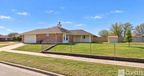 A house with a fence and a tree in front of it.