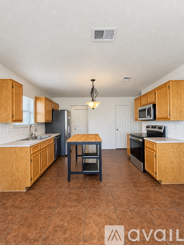 A kitchen with wooden cabinets and a tile floor.