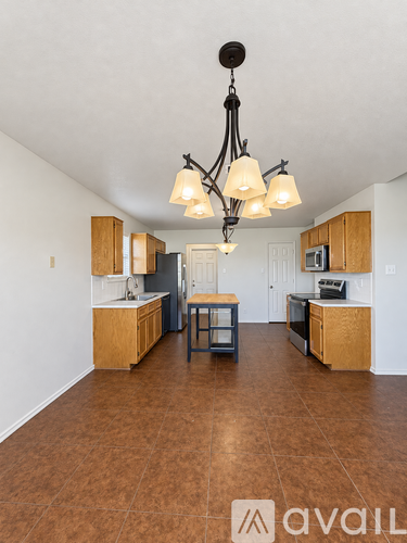 A kitchen with brown floors and a chandelier.