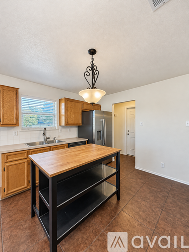 A kitchen with a wooden island in the middle of the room.