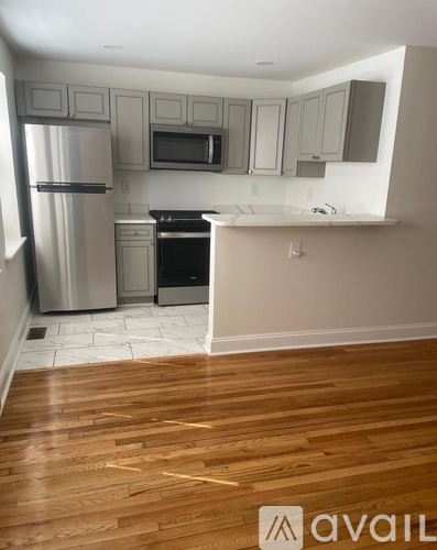 A kitchen with wooden floors and white appliances.