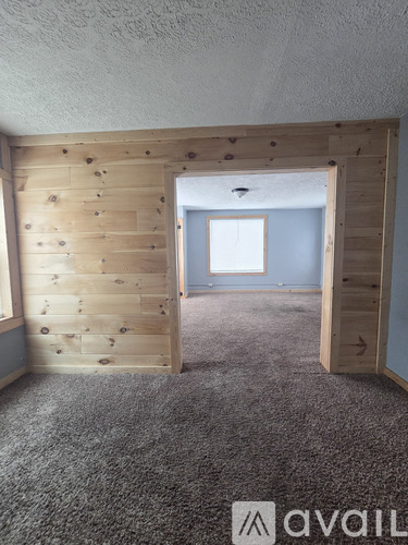 A room with a carpeted floor and a wooden wall.