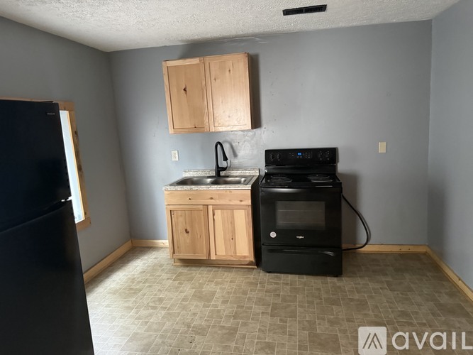 A kitchen with a black fridge, black stove, and black microwave.